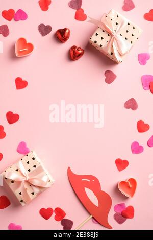 Valentines day romantic vertical banner mockup. Flat lay composition with hearts, gift boxes, candles, decorations on pink background. Gift vouches, g Stock Photo