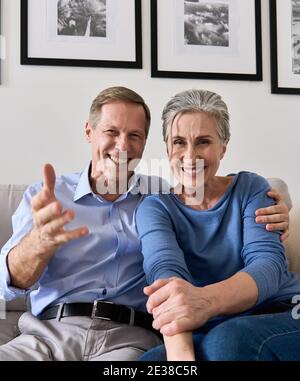 Happy older couple talking to camera making online video call, webcam view.