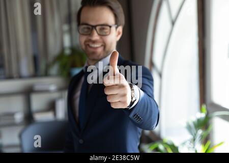 Close up overjoyed businessman wearing glasses showing thumbs up Stock Photo