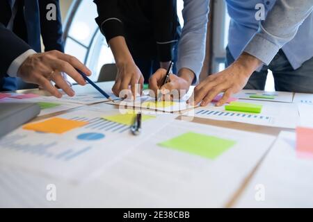 Close up diverse employees working on financial project statistics Stock Photo