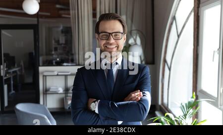 Head shot smiling businessman wearing glasses standing in office Stock Photo