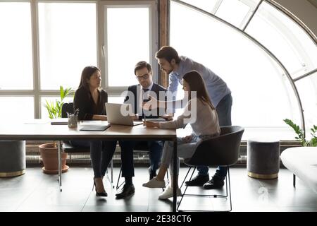 Diverse employees with team leader working on project together Stock Photo