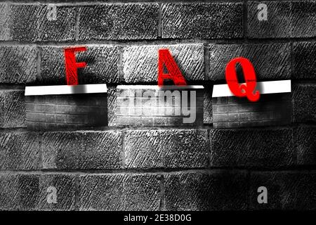 Brick wall with the word FAQ (frequently asked questions). Stock Photo