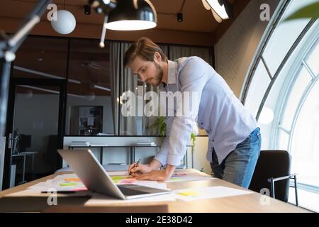 Confident executive businessman working with documents, writing notes on stickers Stock Photo
