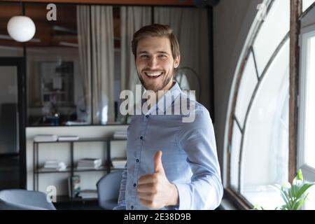 Close up overjoyed businessman showing thumbs up at camera Stock Photo