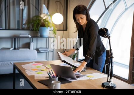Confident Indian businesswoman working with project statistics in office Stock Photo