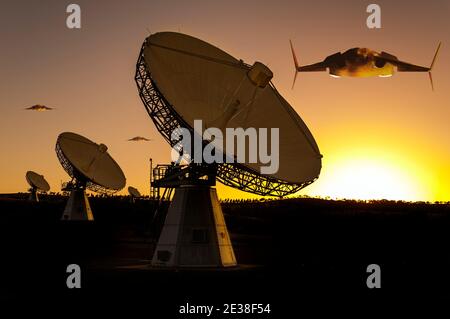 Three futuristic alien space craft approach an array of large telecommunication and satellite tracking dishes that face the sky at sunset. Stock Photo