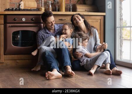 Overjoyed parents have fun play with little kids Stock Photo