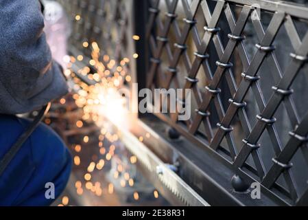 Welding the steel gear racks to gate. Last phase before setting up an automated gate operator. Professional service of installation and maintenance of Stock Photo