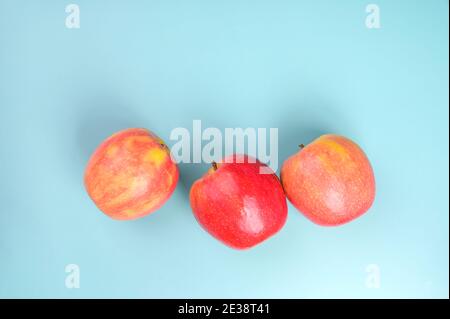Beautiful red rustic apples on a blue background. Free space for text. High quality photo Stock Photo
