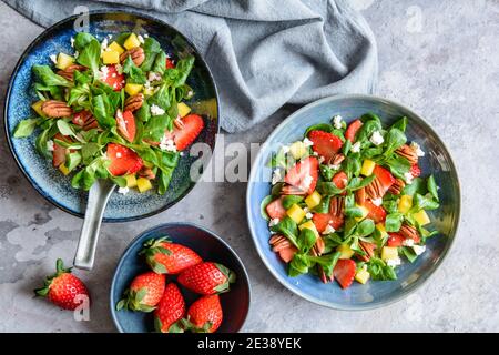 Lettuce salad with mango, strawberry, pecan nuts and Feta cheese Stock Photo