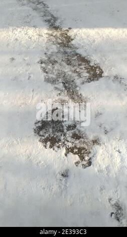 Asphalt road, track partially cleared of snow Stock Photo