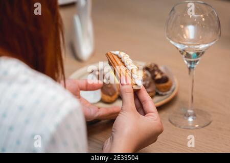 woman going to eat eclait on a food and vine tasting. Eclairs with Stock Photo