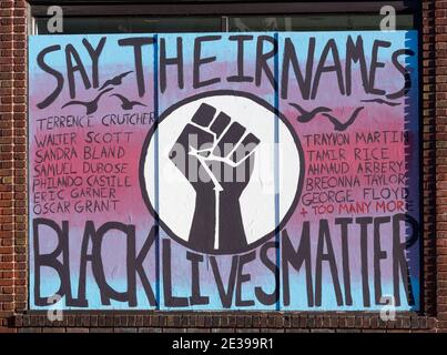 Black Lives Matter mural on a boarded up business with a fist and the slogan of Say Their Names of people who have died from police violence Stock Photo