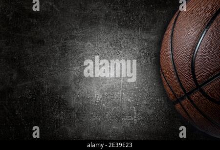 Basketball ball on dark concrete wall texture background. Background for product display, banner, or mockup Stock Photo