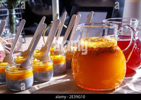 Jugs of soft drinks and jars of fruit smoothies. Fragment of the table setting. Stock Photo
