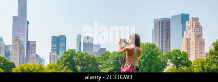 New York City tourist taking photo with phone of NYC Skyline of skyscrapers buildings towers in summer travel vacation panoramic banner background Stock Photo