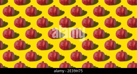 Ripe, juicy pomegranate on a yellow isolated background. The concept of healthy eating. Seamless pattern. Original packaging design. Stock Photo