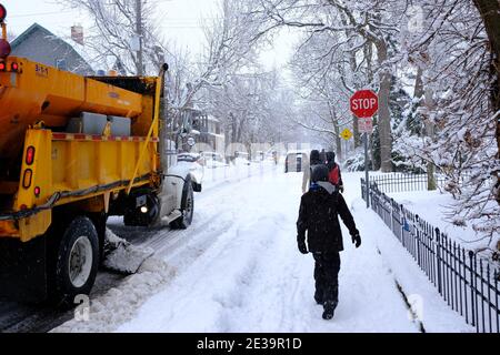 Snowy Ottawa! Scenes from around Ottawa after a fresh dumping of 25cm. A yellow city snow plow slowly passes a group of pedestrians. Ontario, Canada. Stock Photo