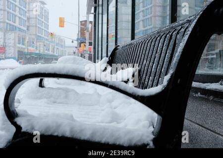 Snowy Ottawa! Scenes from around Ottawa after a fresh dumping of 25cm. Snow covered black metal bench on Bank Street at Holmwood Ave. Ontario, Canada. Stock Photo