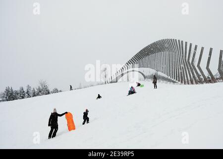 Tobogganing down from the stadium heights to the great lawn at Landsowne on a snowy winter's day in Ottawa, Ontario, Canada. Stock Photo