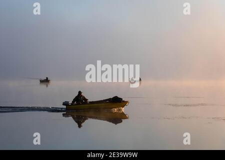 Fishing boats on the lake in the morning. Morning mist. Copy space Stock Photo