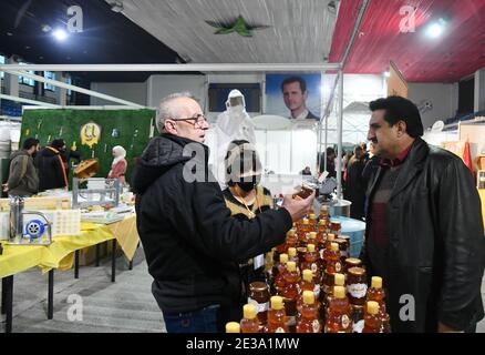 Damascus, Syria. 17th Jan, 2021. People attend an exhibition showcasing various types of locally-made honey and equipment for honey makers in Damascus, Syria, on Jan. 17, 2021. Credit: Ammar Safarjalani/Xinhua/Alamy Live News Stock Photo