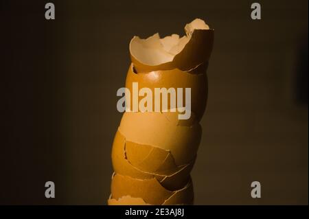 A towering stack of cracked egg shells show a variety of pastel colors. Stock Photo