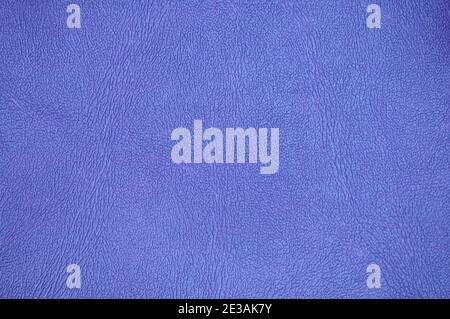 A fragment of genuine leather with folds, artificially colored in a bright blue saturated color. Background, texture, close-up. Stock Photo