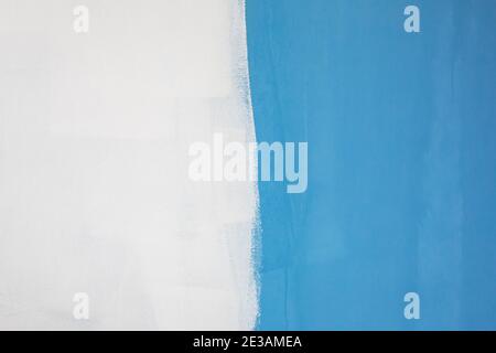 Half of the white wall painted in blue. Stock Photo