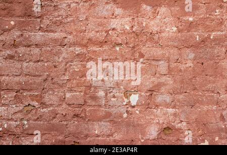 Full frame abstract background of an antique rose color painted brick wall texture with a shabby chic artsy appearance from uneven deterioration Stock Photo