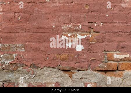 Full frame abstract background of an antique rose color painted brick wall texture with a shabby chic artsy appearance from uneven deterioration Stock Photo