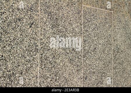 Full frame abstract texture background of a vintage exterior smooth granite stone wall surface, showing mild wear and staining from aging Stock Photo