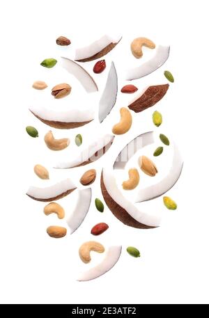 Falling nuts in closeup on white backgrounds.. Nuts of coconut, peanut, cashew and pumpkin seed . Stock Photo