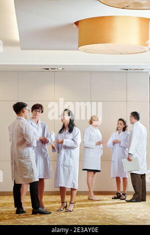 Scientists standing in hall and talking about new researches that were discussing during conference Stock Photo