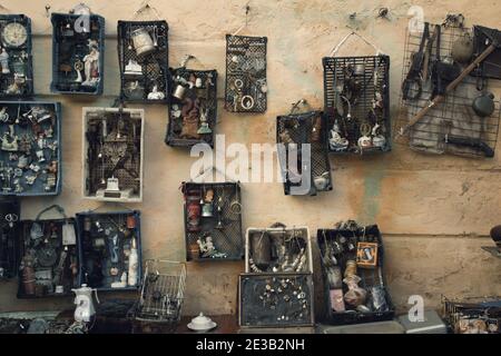 Lviv, Ukraine - January 02, 2021. Aged wall with different antiques on flea market Vernisazh with dolls, toys and vintage things. Collectibles memorab Stock Photo