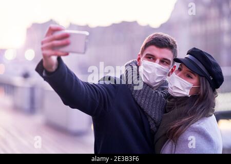 Happy couple celebrating Valentines Day in masks during covid-19 pandemic Stock Photo