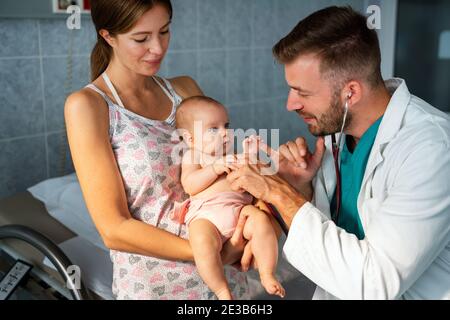 Portrait of happy mother with baby, medical pediatrician doctors, nurse Stock Photo