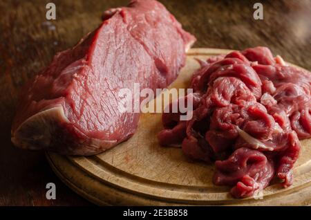 Portioned slices of raw meat on a cutting board. Fresh pieces of chopped  beef tenderloin close-up. Five juicy slices of beef. Ingredients for  preparin Stock Photo - Alamy