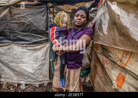 Beatrice Kakau a 28 year old mother with her child sits inside