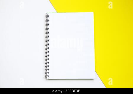 Top view of an open notebook against white and yellow background Stock Photo