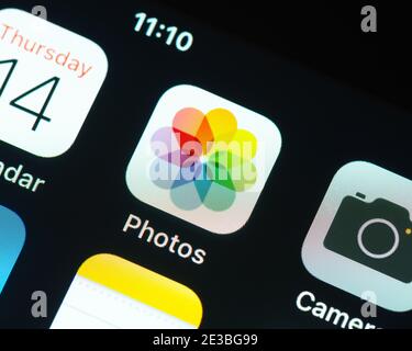 Apple Photos app icon on Apple iPhone screen. Photos is a photo management and editing application. Stock Photo
