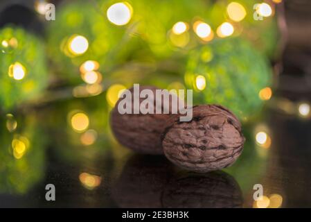 Two walnuts on a black table with bokeh lights, close up, macro photography Stock Photo