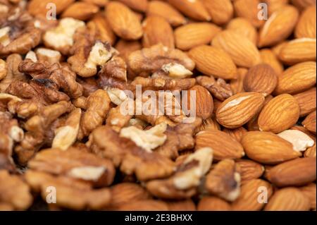 Almonds and walnuts scattered on the table. Close-up, selective focus Stock Photo