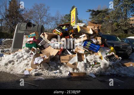 Madrid, Spain - January 10, 2021: Accumulated garbage, not removed for days by the public services of the town hall, stinks half frozen by ice, after Stock Photo