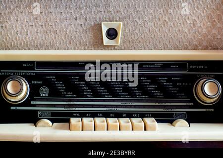 Close up of the old Polish radio dial. Wood vintage antique analog radio. Retro display with buttons, knobs, speaker with list of cities in Polish. Stock Photo