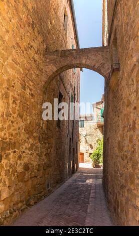 A stone archway across a street in the village of Pienza in Siena Province, Tuscany, Italy Stock Photo