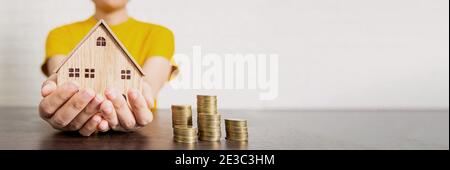 real estate, woman holding house and money on table, bet offer and low interest concept Stock Photo
