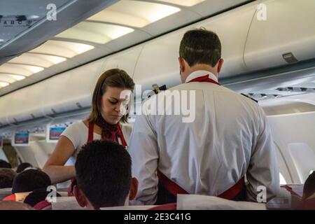 Cabin crew serving refreshments in economy class on an Airbus 320 - TAM Linhas at Brasilia International airport in Brasilia, capital city of Brazil. Stock Photo