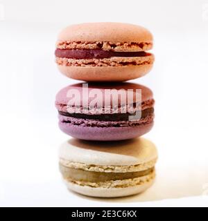 Apricot, fig and vanilla macarons stacked at a white table Stock Photo